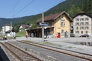 Two-story building with gabled roof next to double-track railway line