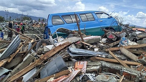 Sebuah mobil terjebak di antara reruntuhan bangunan