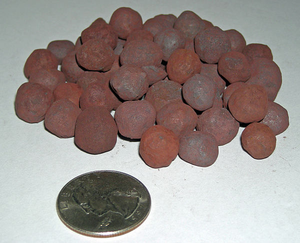 Processed taconite pellets as used in the steelmaking industry, with a US quarter shown for scale.