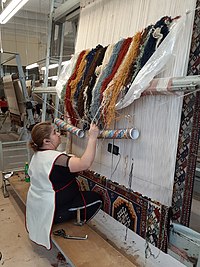 The woman making a carpet and watching TV series.jpg