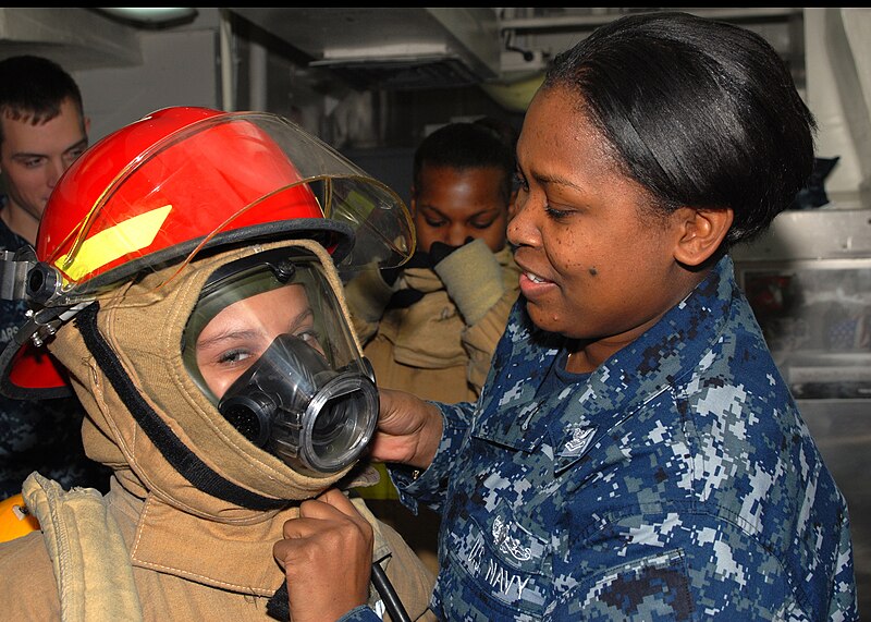 File:US Navy 091221-N-9643W-421 Damage Controlman 2nd Class Tiffany Epps, a member of the damage control team helps a child from the Virginia Home for Boys and Girls (VHBG) don the full fire fighting ensemble.jpg