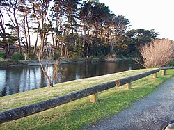 Der Waikanae River von seinem Südufer in Otaihanga aus gesehen. Auf der anderen Seite des Flusses liegt die Stadt Waikanae Beach.