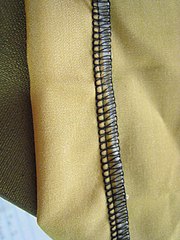 A five-thread overlock hem made with a serger machine. This photo shows the inside of the garment. On the outside of the garment, this would appear as a blind stitch.
