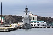 JS Asuka neo đậu tại cầu tàu Hemi Kade, Căn cứ Hải quân Yokosuka vào ngày 22 tháng 2 năm 2017. Phía sau ở cầu tàu Y5 là JS Enshu (AMS-4305)