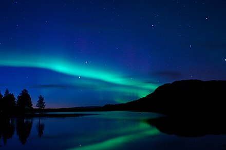 Northern lights mirrored in lake at Alta