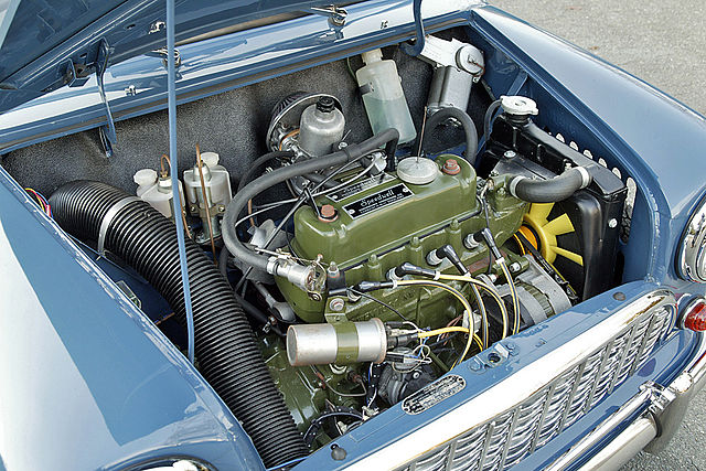 The bonnet on this original Mini is open, showing the transversely mounted engine that drives the front wheels.