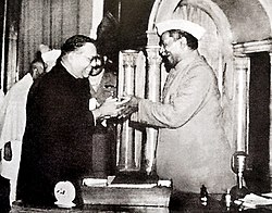 Dr. Babasaheb Ambedkar, chairman of the Drafting Committee, presenting the final draft of the Indian Constitution to Dr. Rajendra Prasad on 25 November, 1949.jpg