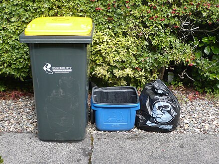 Kerbside collection bins in Dunedin, New Zealand. The yellow-liddied wheelie bin is for non-glass recyclables, and the blue bin is for glass. The two bins are collected on alternating weeks. Official council bags are used for general household waste, and are collected weekly.