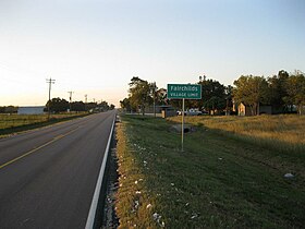 A Fairchilds sign is on FM 361 looking northwest. Bits of cotton from the 2012 harvest lie along the roadside.