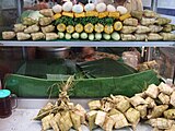 Кетупати на базарному лотку серед овочів. Індонезія