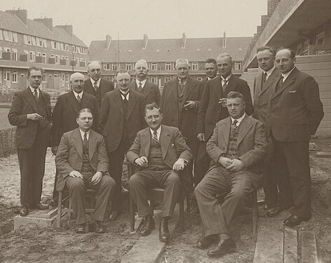 Groepsfoto op het binnenterrein van het bouwblok Oliemuldersweg (links), Klaprooslaan (midden) en Nachtegaalstraat (rechts) in de Oosterparkwijk, Groningen: Kazemier (derde van links), Tonko Tonkens (tweede van rechts) en wethouder Eltjo Rugge (vijfde van rechts)