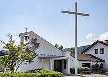 Kirche mit großem frei stehendem Kreuz daneben