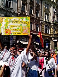 A participant of 2013 Prague Pride wearing a traditional Moravian dress (Hanakia) and a sign "Good day - Olomouc greets Prague" Prague Pride 2013 - Moravian dress.jpg