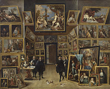 Un petit groupe d'homme évolue dans une pièce remplie de tableaux.