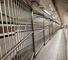 Passageway linking the ticket office to the platforms, looking towards the latter. Note tidal flow segregation, in operation on football match days. The fans would use the wider section. Tidal segregation at Arsenal, 2021.jpg