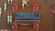 Texas Instruments TMS1100 microcontroller inside the Parker Brothers Merlin electronics game. Tms1100-merlin.png