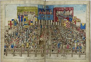 Depiction of a late medieval knightly tournament from King Rene's Tournament Book (1460s). The two teams stand ready, each side has 24 knights, all with heraldic surcoats and caparisons, and each accompanied by a banner-bearer with a heraldic flag. There is a central spectators' box for the four judges, where the heraldic shields of the competitors are displayed, the two teams being led by the dukes of Brittany and Bourbon, respectively, and one spectator box on each side for the ladies; inscribed over the boxes is plus est en vous, the heraldic motto of the Gruuthuse family of Bruges, attributed to tournament between Jean III de Gruuthuse and Jean de Ghistelles held in 1393. The two dukes can be seen facing each other in the center of the front lines, each with a personal heraldic flag as well with a larger flag of the same design representing their team. The chief herald is also on horseback, between the two teams, wearing his own heraldic colours. Turnierbuch des Rene von Anjou 22.jpg