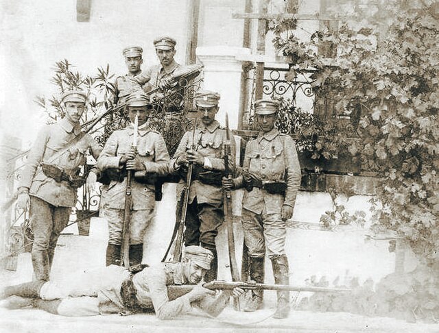Fotografia przedstawia grupę mężczyzn w mundurach pozującą na ganku. Czytaj również podpis zdjęcia.