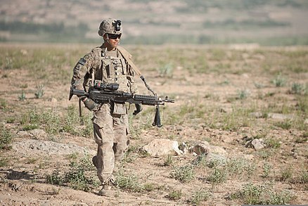 An Infantryman with Bravo Company, 3rd Battalion, 15th Infantry Regiment, 4th Infantry Brigade Combat Team, carries an M240L machine gun while on a foot patrol in Wardak province, Afghanistan, 2013