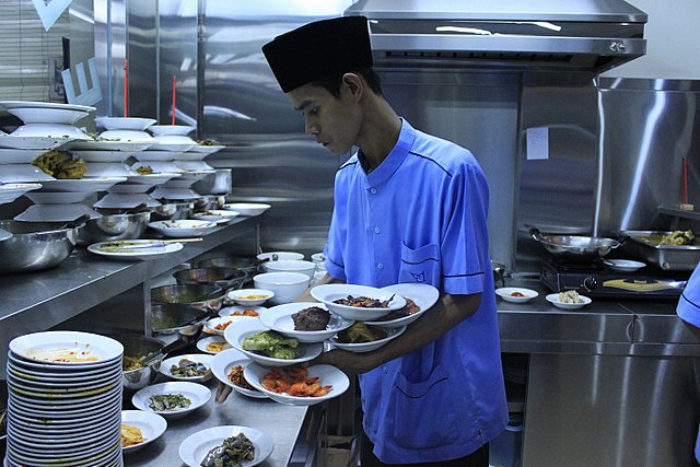 Padang restaurant waiters are known for their exceptional skill of carrying multiple plates in their hands when serving the hidang style.