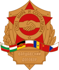 סמל ברית ורשה; הכיתוב בסמל (בחלק העליון): ברית השלום והסוציאליזם; בשורה התחתונה: ברית ורשה
