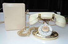 A Western Electric 202 Imperial telephone as issued in 1955 with a gold lacquered base and ivory Tenite plastic handset. The subscriber set (rear) was painted in harmonizing color to the desk set. Western Electric 202 Imperial telephone with 684A subset dated 1955.jpg