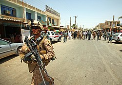 Afghan and US officials walking on one of the main streets of Zaranj