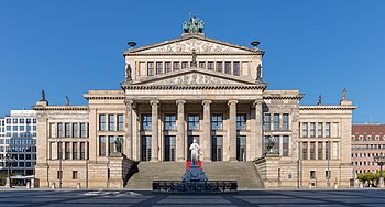 Une grande salle de concert de style néoclassique, avec six colonnes et de nombreuses sculptures décoratives