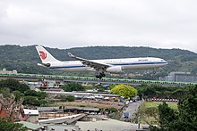 Aircraft operate flights to Taiwan by Air China - the flag carrier of the PRC -- are required to cover the PRC flag painted on the body. Air China Airbus A330-343 B-6523 on Final Approach at Taipei Songshan Airport 20150321b.jpg