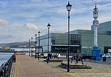 An 1868 clock tower designed by Clark features in front of Greenock's Custom House, and was dubbed "The Beacon", a name adopted by the Greenock Arts Guild for its new Beacon Arts Centre. Beacon Arts Centre & clock tower.jpg