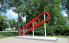 This red paper clip sculpture was installed in 2007 at Bell Park in Kipling as a monument to the series of trades made by MacDonald. At the time, it was the world's largest paper clip. Bell Park paperclip IMG 5203 (14616044776).jpg