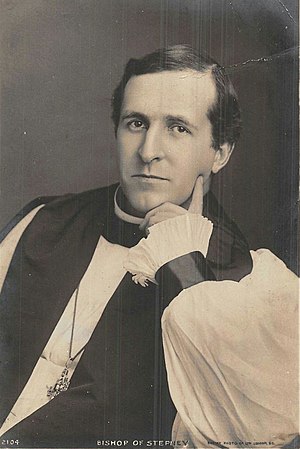 Black-and-white photo of a dark-haired white man, seated and resting his left hand around his chin, dressed in bishop