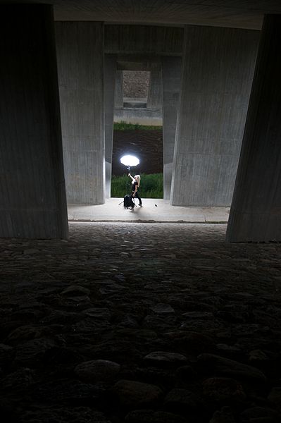 File:Blond woman in black clothing under cement pilars 02.jpg