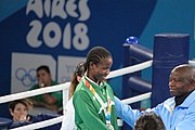 Deutsch: Boxen bei den Olympischen Jugendspielen 2018 Tag 12, 18. Oktober 2018 - Medaillenzeremonie im Fliegengewicht der Mädchen - Gold: Martina La Piana (Italien), Silber: Adijat Gbadamosi (Nigeria), Bronze: Heaven Destiny Garcia (USA); Medaillenübergabe durch Habu Gumel (IOC, Nigeria), Geschenkübergabe durch Dr. Joseph O. Ayeni (Nigeria, AIBA). English: Boxing at the 2018 Summer Youth Olympics on 18 October 2018 – Girl's flyweight Medal Ceremony - Gold: Martina La Piana (Italy), Silver: Adijat Gbadamosi (Nigeria), Bronze: Heaven Destiny Garcia (USA); Medal handover by Habu Gumel (IOC, Nigeria), Gift presented by Dr. Joseph O. Ayeni (Nigeria, AIBA). Español: Boxeo en los Juegos Olímpicos Juveniles de Verano de 2018 en 18 de octubre de 2018 - Ceremonia de la Medalla de peso mosca para niñas - Oro: Martina La Piana (Italia), Plata: Adijat Gbadamosi (Nigeria), Bronce: Heaven Destiny Garcia (Estados Unidos); Entrega de medallas por Habu Gumel (COI, Nigeria), Regalo presentado por Joseph O. Ayeni (Nigeria, AIBA).