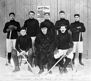 Group photo of the Dawson City Nuggets on January 14, 1905, posed outside Dey's Arena Dawson City Nuggets.png