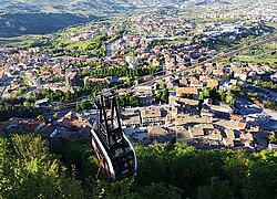 Vue d'une cabine à son arrivée à la gare de la ville de Saint-Marin avec Borgo Maggiore en contrebas.