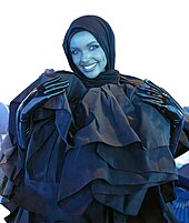 Halima Aden schaut direkt in die Kamera und trägt ein dunkles Kopftuch.