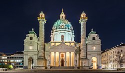 A Károly-templom (Karlskirche) homlokzatának éjszakai látképe (Bécs, Ausztria). A barokk templomot Borromei Szent Károlynak szentelték, és a város egyik legnagyobb épülete