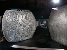 Host press used to bake sacramental bread inscribed with religious symbols. Host presses like this developed alongside early waffle irons. Kleste na hostie detail.jpg