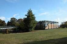 Le musée Argentomagus en 2009 ; bâtiment en brique rouge et verre au milieu d'un parc, rejoint par une passerelle de métal venant de la gauche.