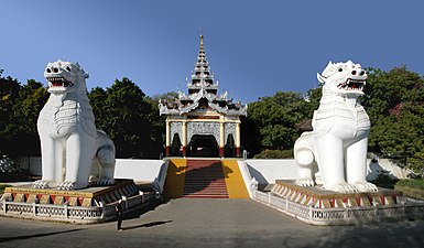 Ein Paar weißgekalkter Chinthe bewacht den Eingang zum Mandalay Hill.