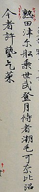 Two vertical lines of Japanese text written in calligraphy, read right to left. The first character has smaller, simpler red characters written around it.
