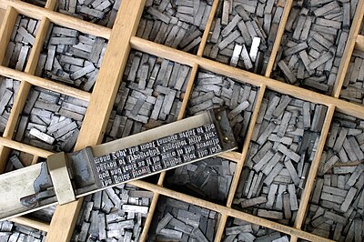 Movable type on a composing stick on a type case