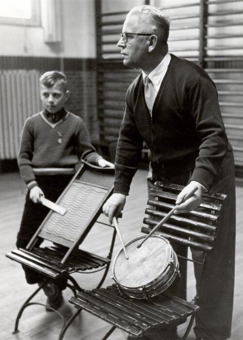 An elementary music teacher instructing a child in 1957 in the Netherlands.