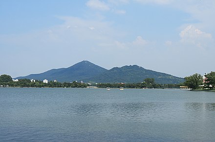 Purple Mountain or Zijin Shan, located to the east of the walled city of Nanjing, is the origin of the nickname "Jinling". The water in the front is Xuanwu Lake