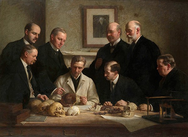 Group portrait of the Piltdown skull being examined. Back row (from left): F. O. Barlow, G. Elliot Smith, Charles Dawson, Arthur Smith Woodward. Front