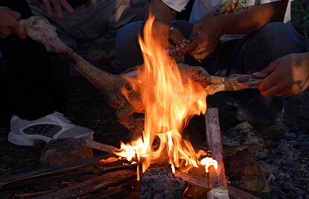 Cooking pinikpikan, shown here is a duck quickly scorched with fire to burn out the remaining feathers.