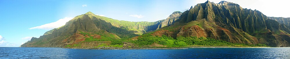 vista de la costa de Nā Pali desde el océano.  Es parte del Parque Estatal de la Costa de Nā Pali, que abarca 6175 acres (20 km2) de tierra y está ubicado en el lado noroeste de Kauaʻii.