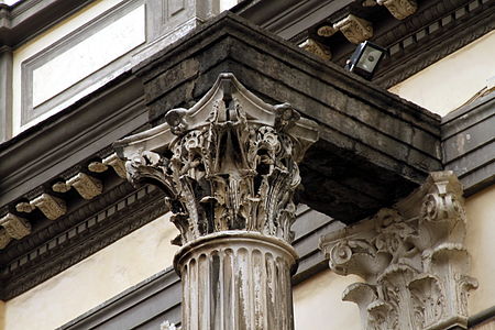 Detalhe do capitel coríntio e a arquitrave de uma das colunas antigas na fachada da basílica.