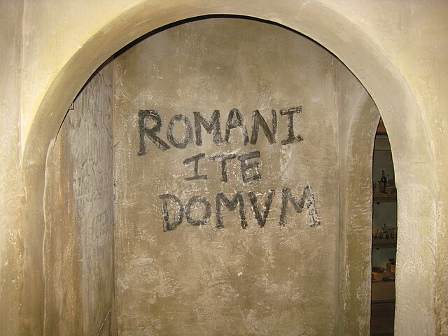 Romani ite domum ("Romans go home"); recreation of the anti-Roman slogan (in the Hull and East Riding Museum) that Brian writes on the walls of the Je